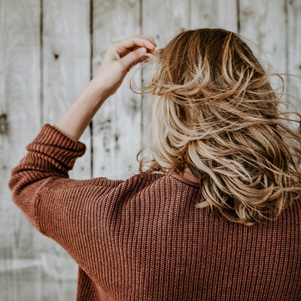 A woman tousling her blonde hair.