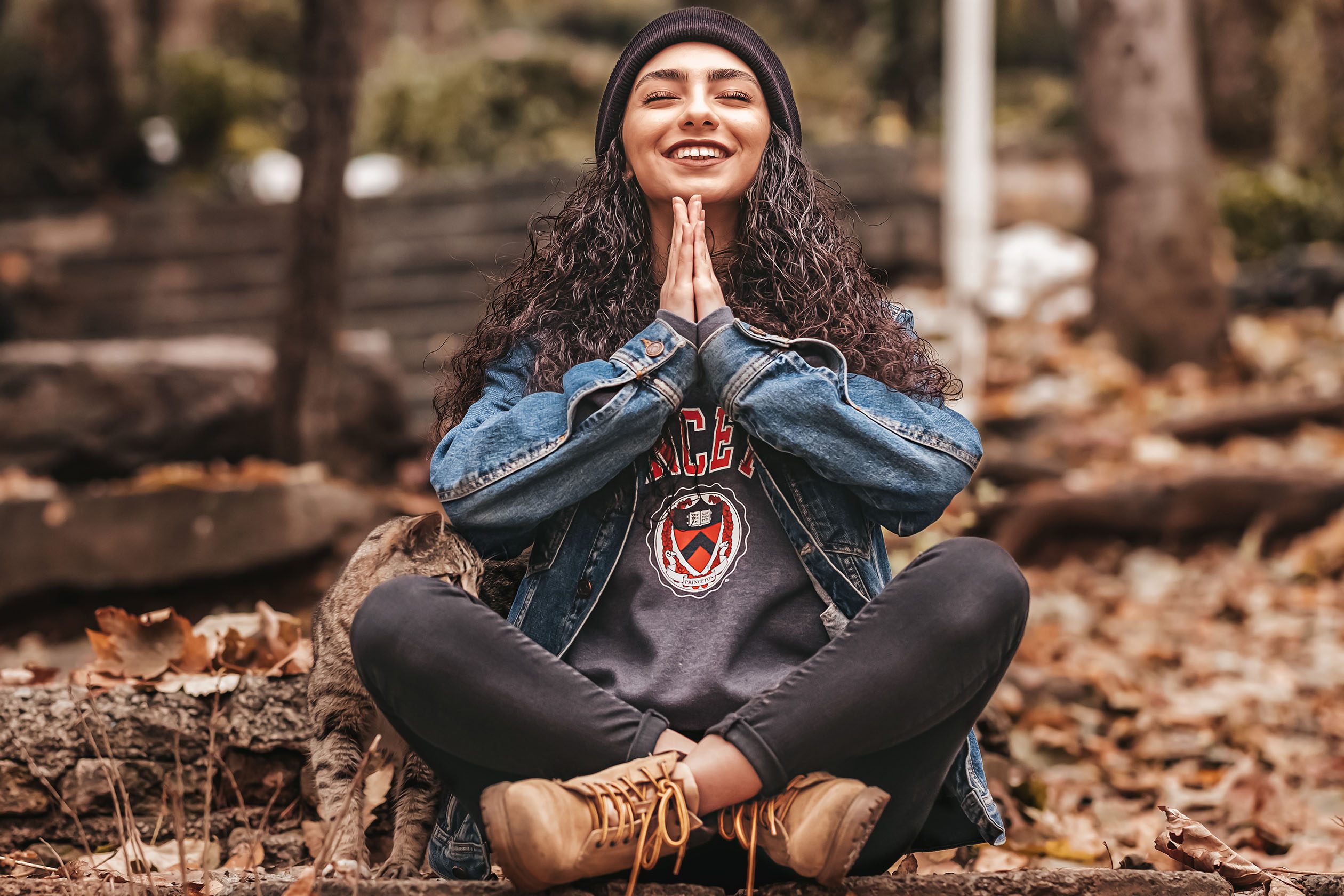 woman meditating in the forest with a cat