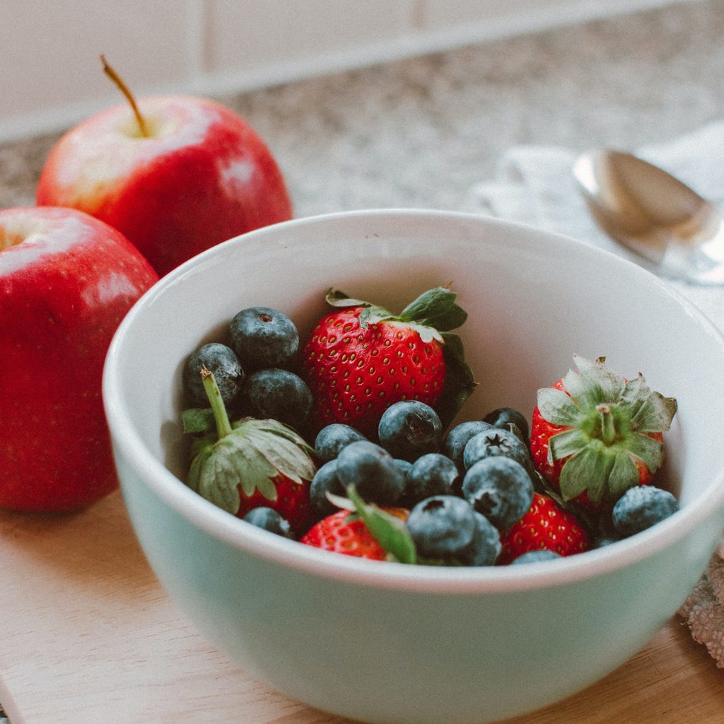 apples and berries in fruit bowl