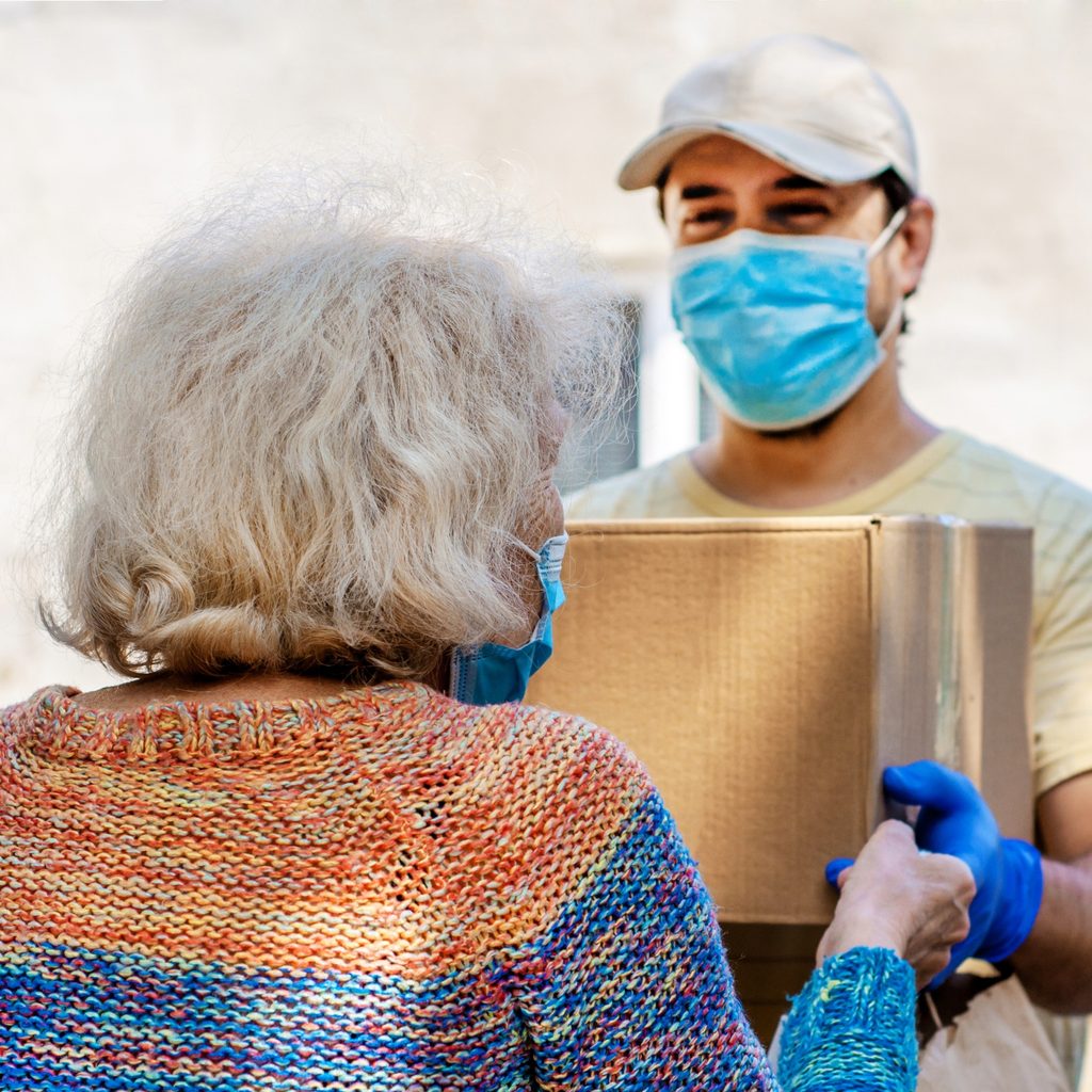 male volunteer gives box to elderly woman