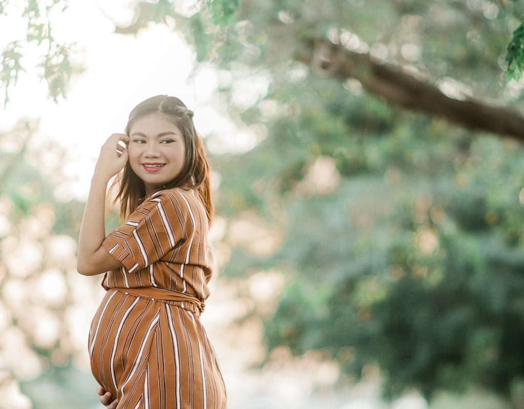 A pregnant woman standing outside
