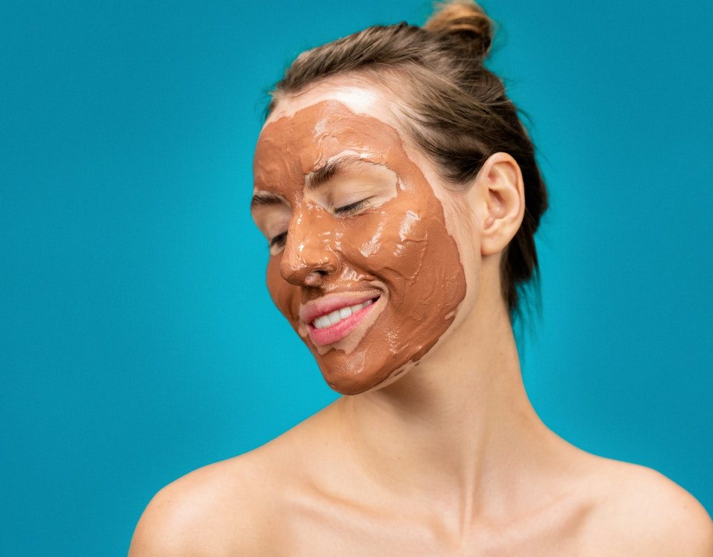 A woman with a mud mask on