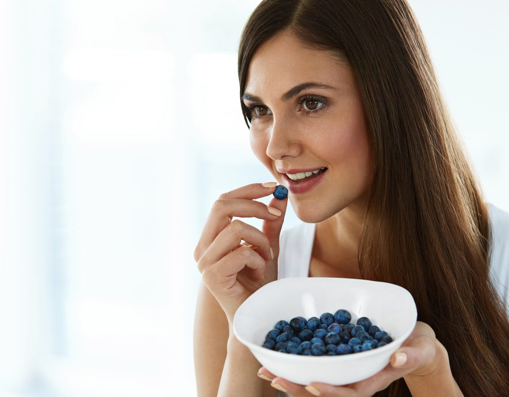 A woman eats blueberries to boost memory