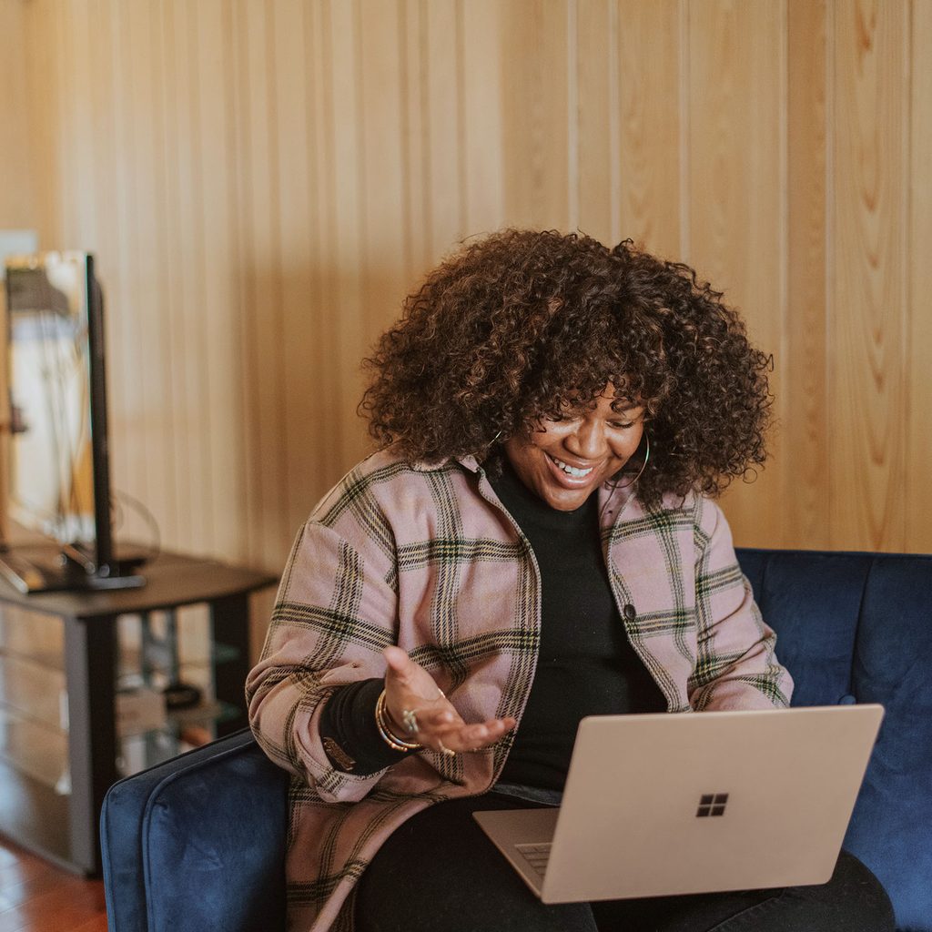 Woman happily using laptop