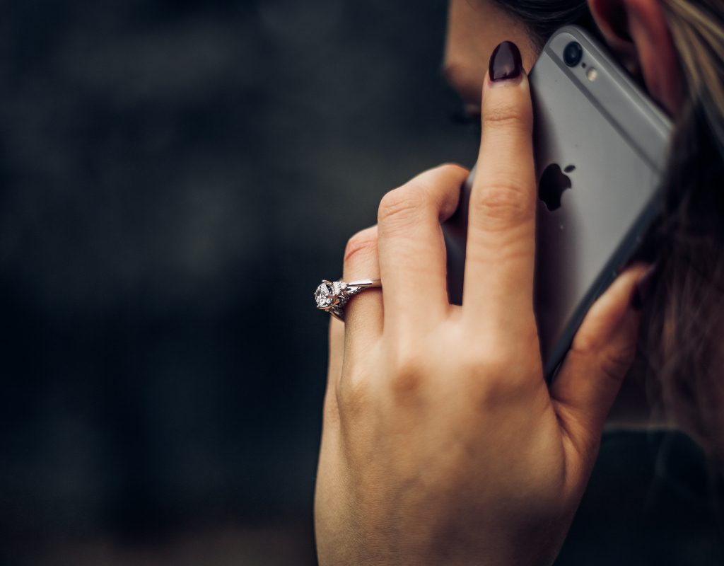 A woman on the phone wearing a wedding ring