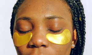 A female with an under eye treatment on her face.
