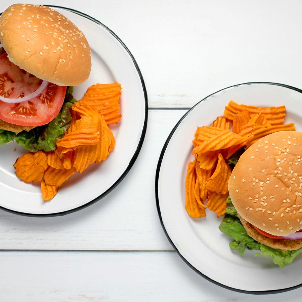 Two veggie burgers with chips