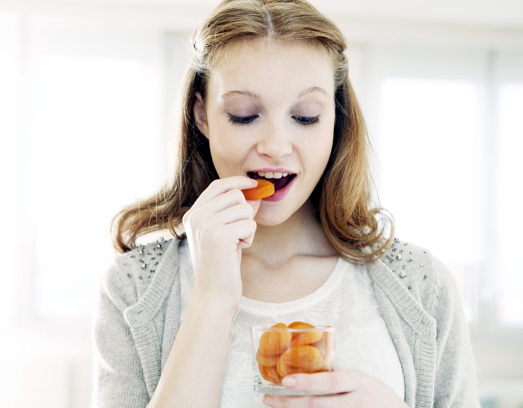 Woman eating dried apricots