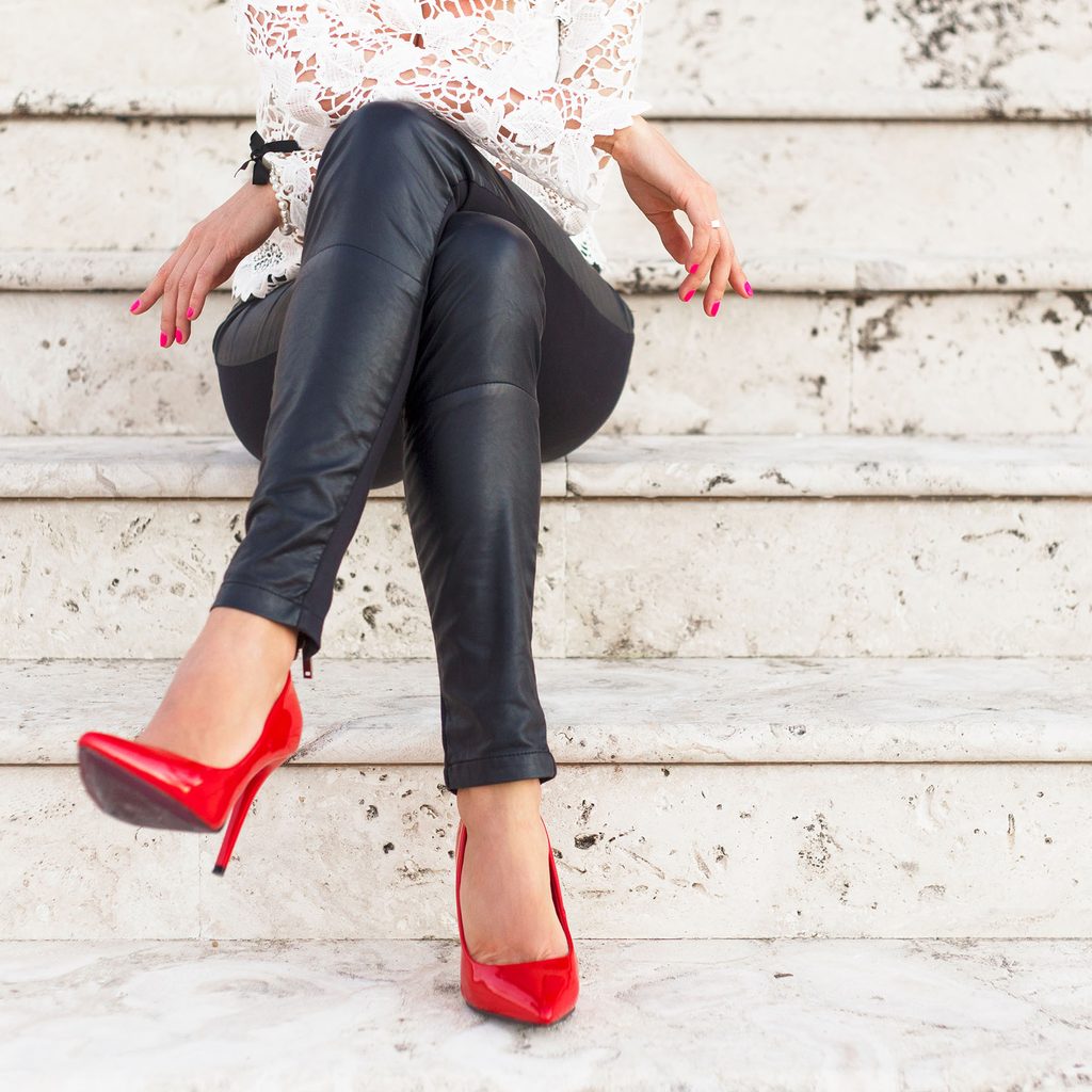 Woman wearing faux leather leggings and red heels