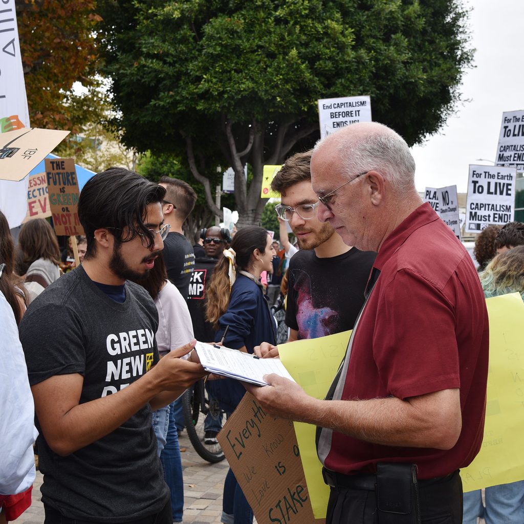 Man signing a petition at a protest