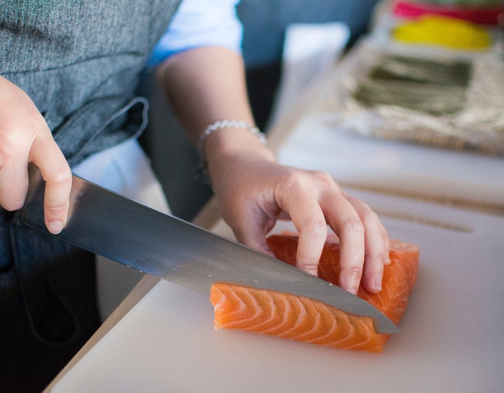 person-cutting-salmon-large-knife