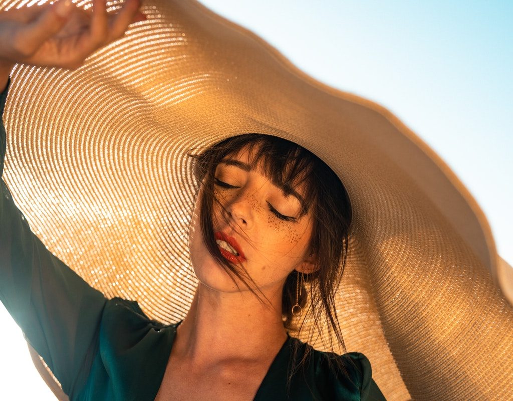A woman wearing a hat to protect her from the sun.