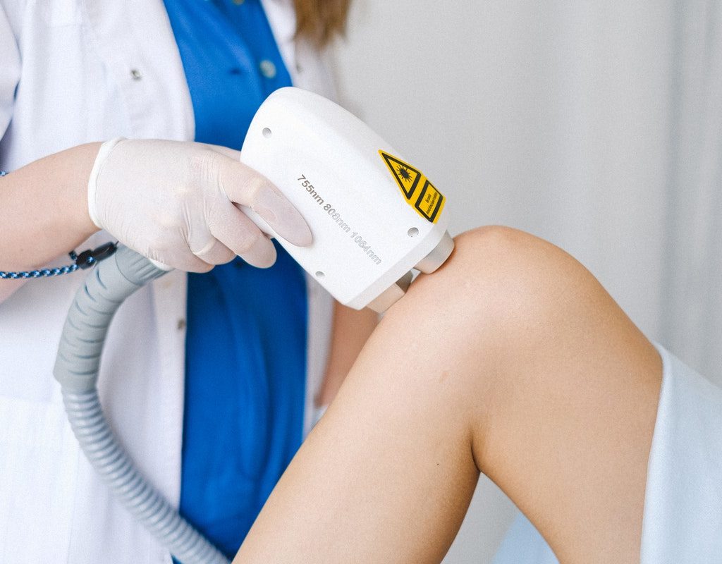 A woman getting laser hair treatment on her leg.