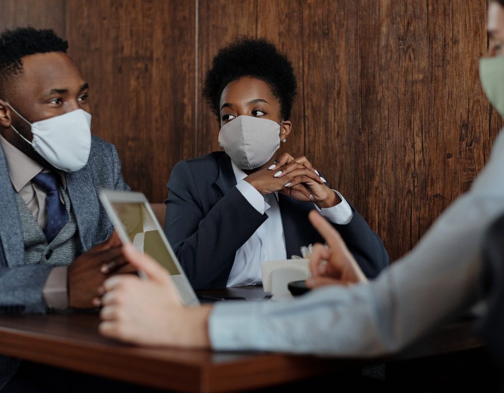 A group of people wearing face masks during a meeting.
