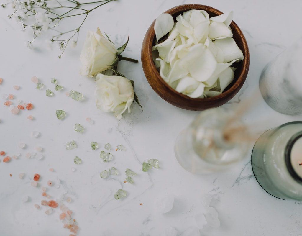 A candle and other relaxing items on a table.