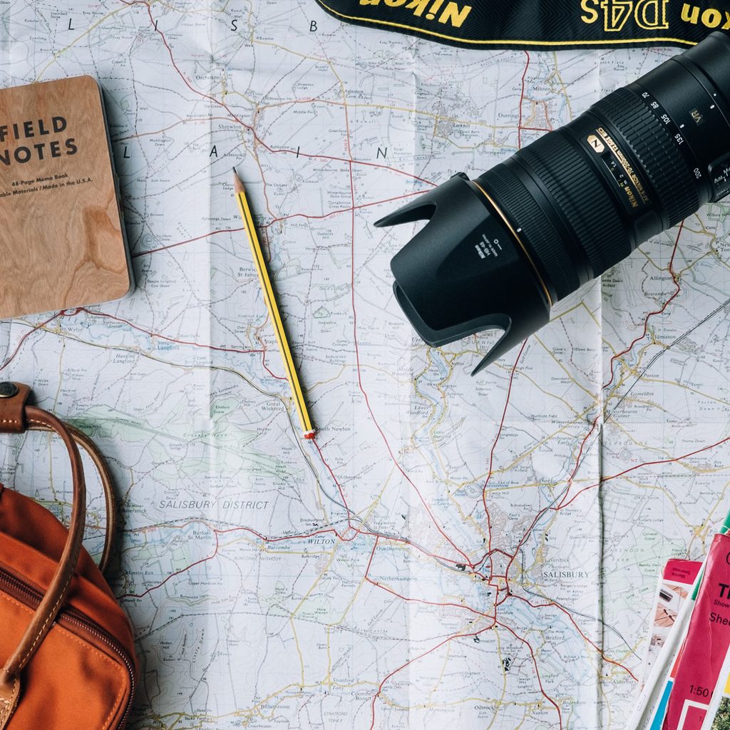 Travel flat lay photo with camera and maps