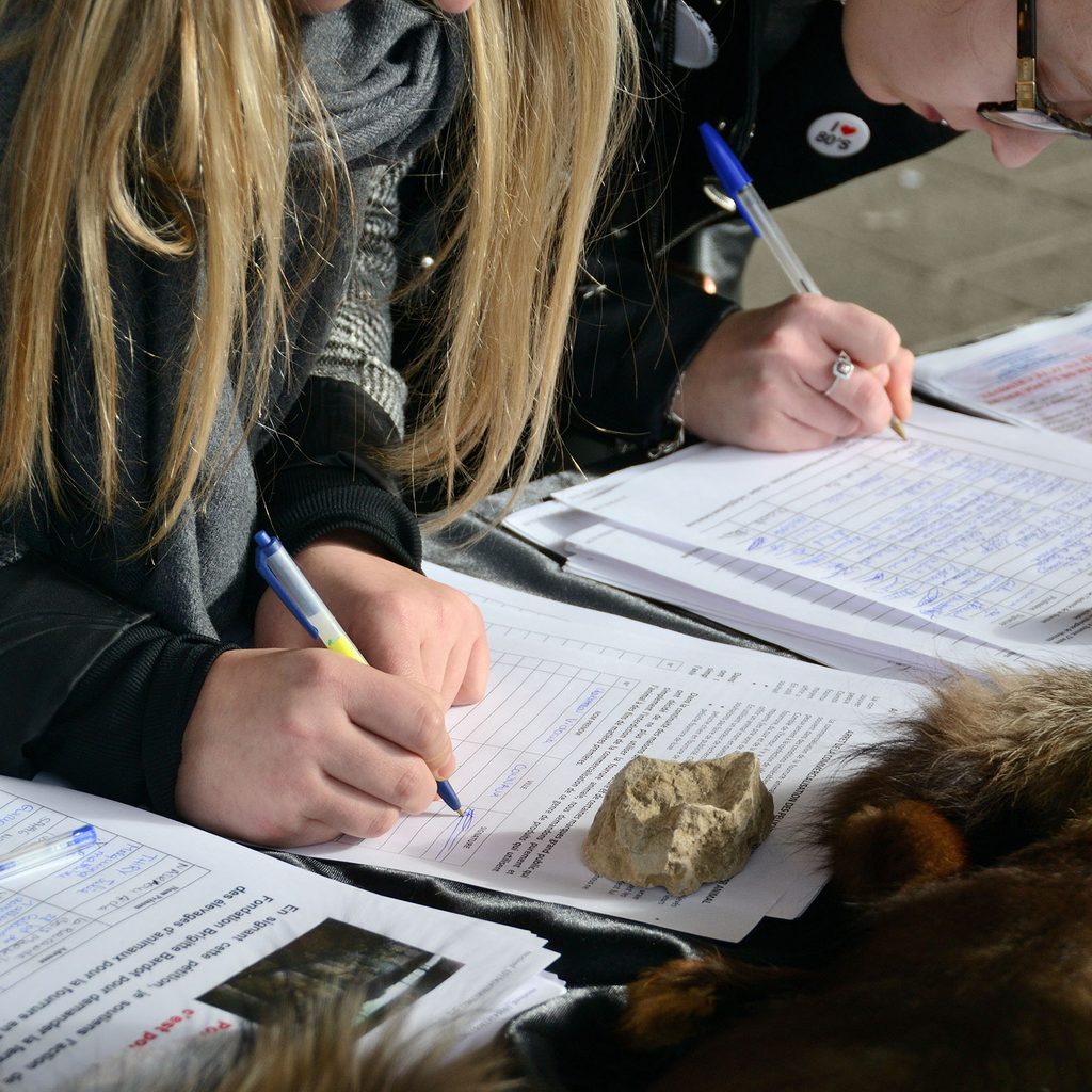 Two women signing petitions