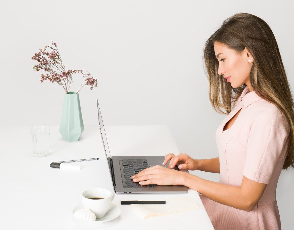 woman-in-pink-dress-sitting-at-white-desk