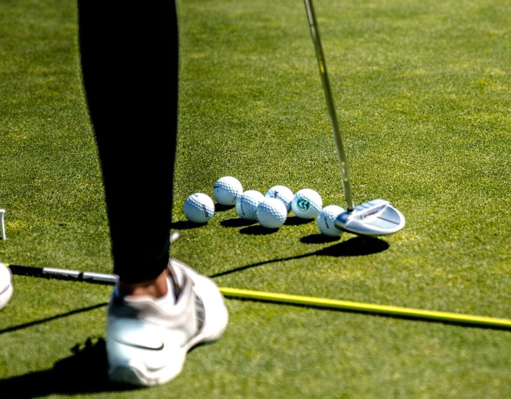 woman-in-white-sneakers-golfing-on-tee