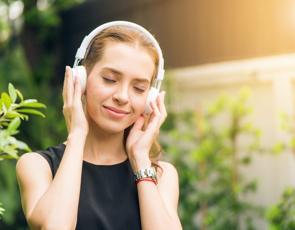 woman-listening-to-podcast-on-big-white-headphones