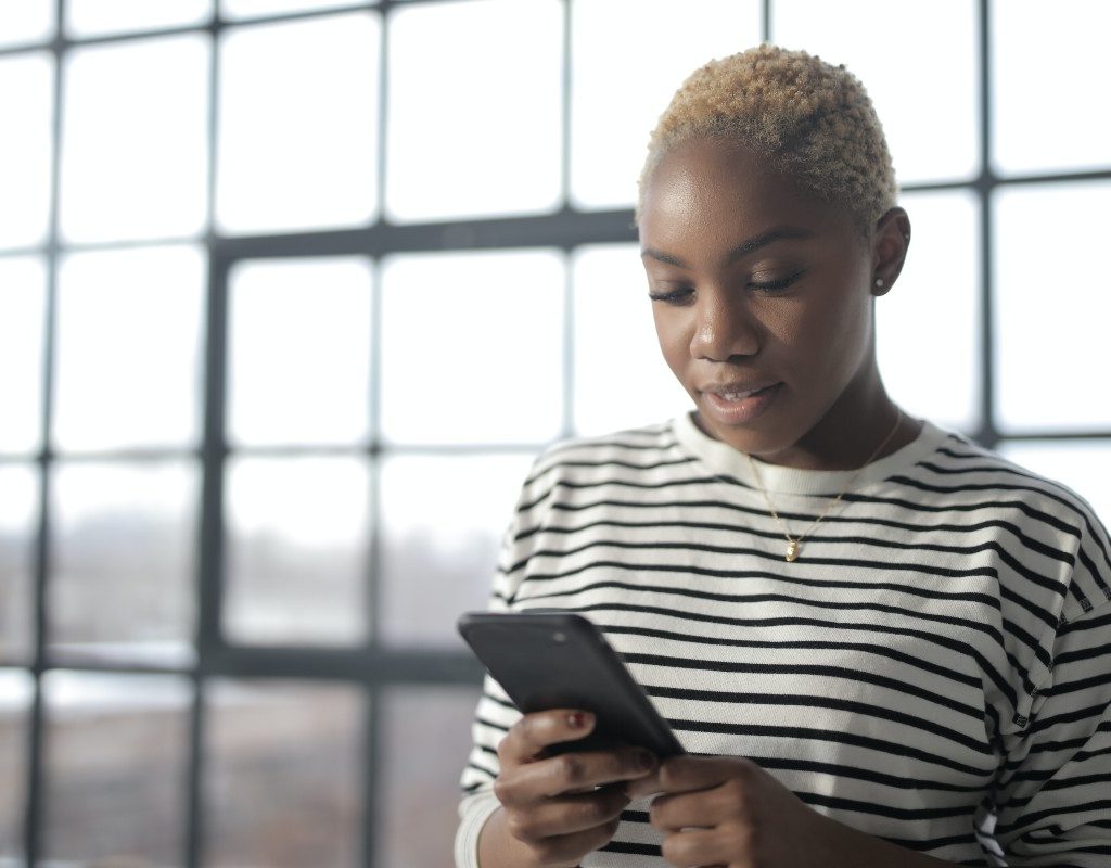 woman-looking-at-phone-near-windows
