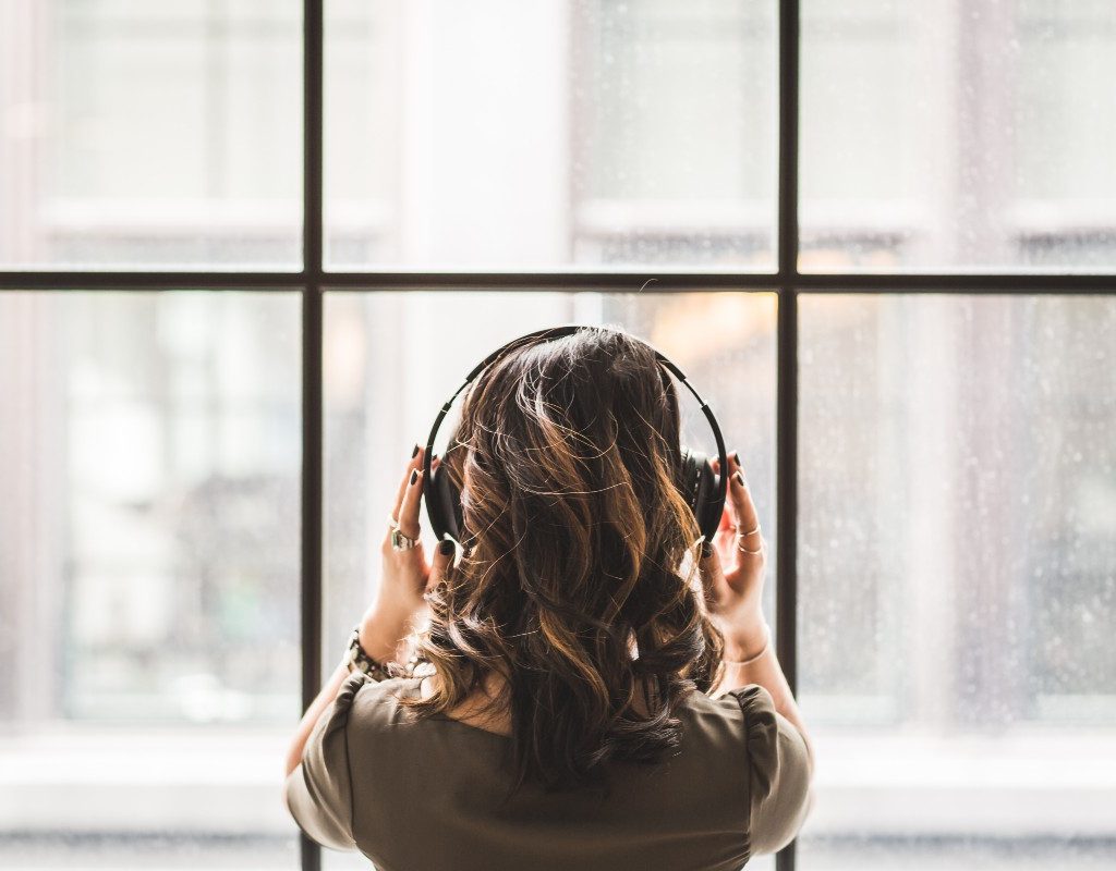 woman-relaxing-listening-to-podcast-by-window