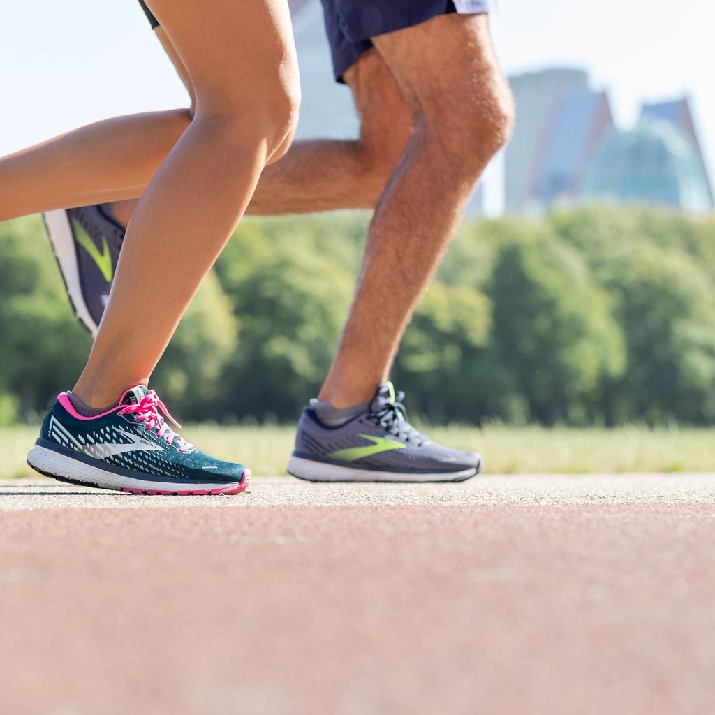 Closeup of two people running in Brooks Ghost 13 shoes
