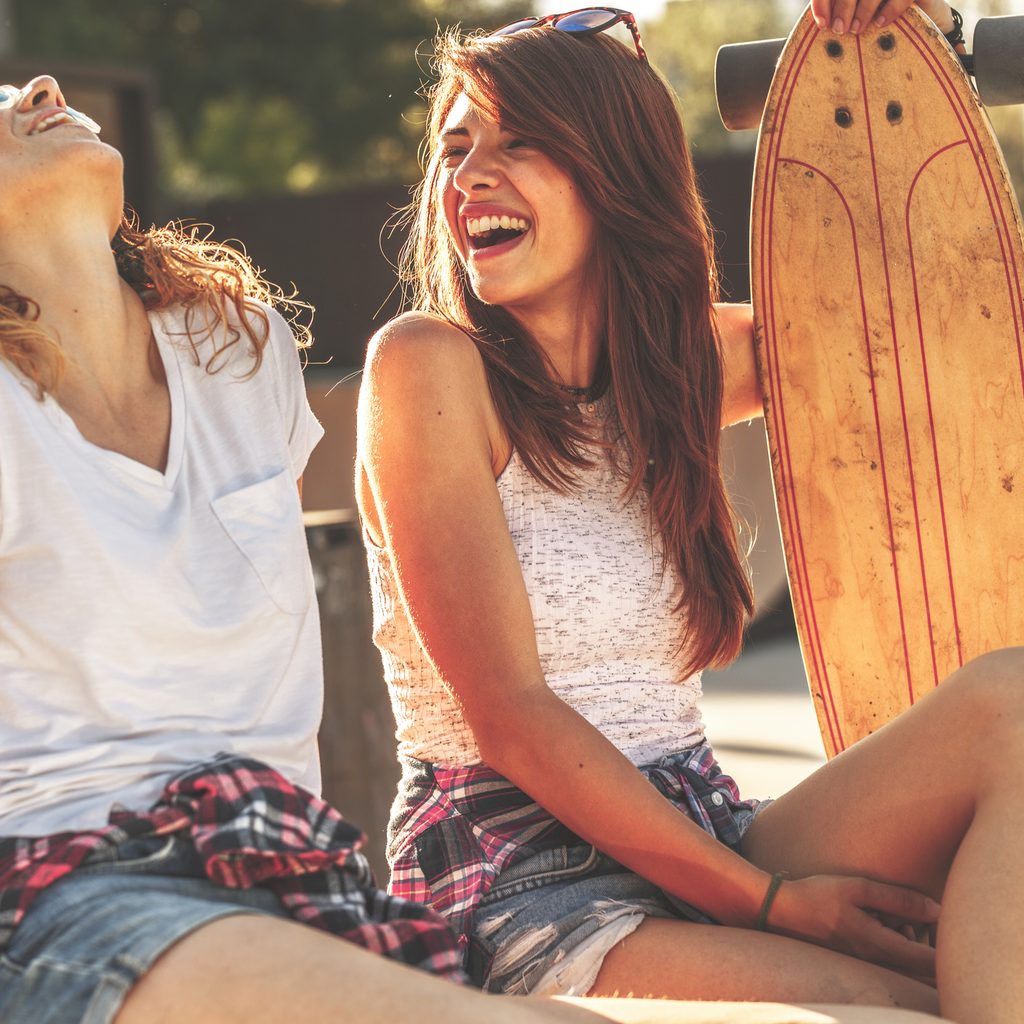 Two friends laughing at skate park