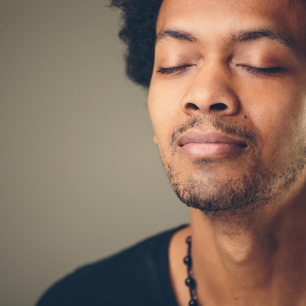 Man with eyes closed taking a deep breath