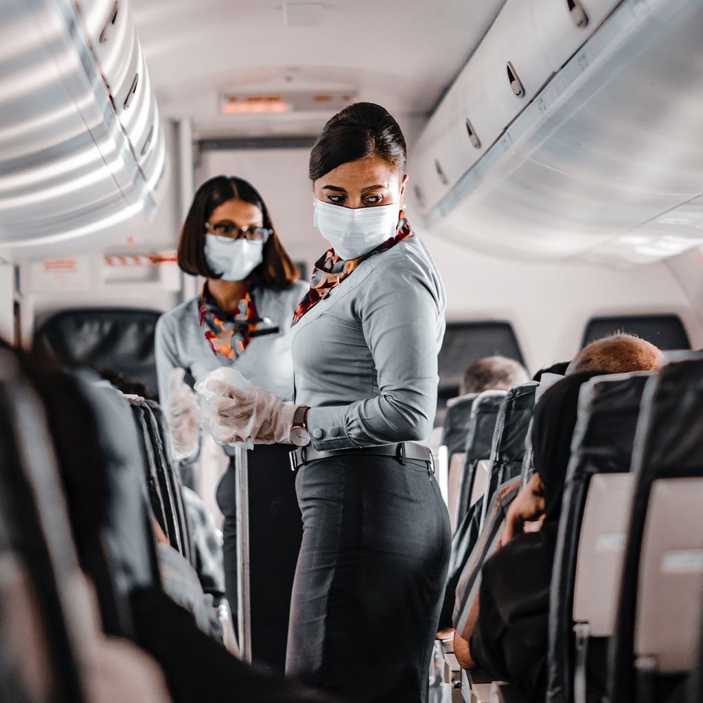Masked flight attendants on a plane
