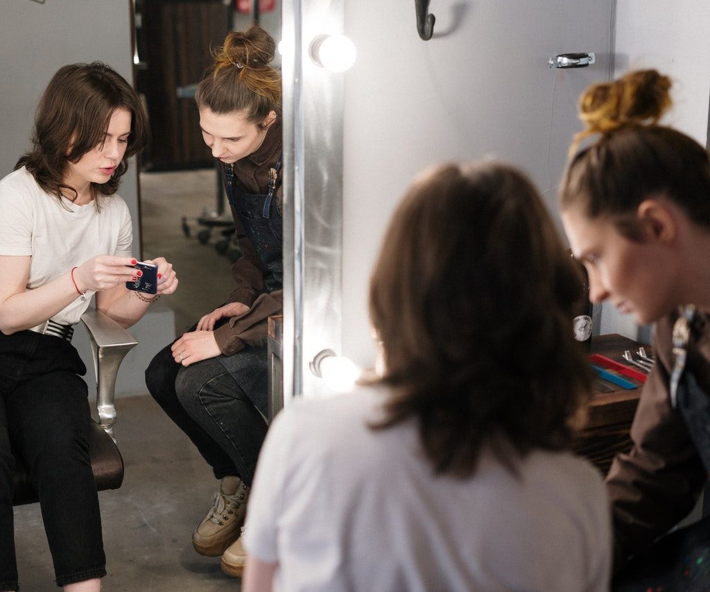 A woman and her stylist looking at hair styles.