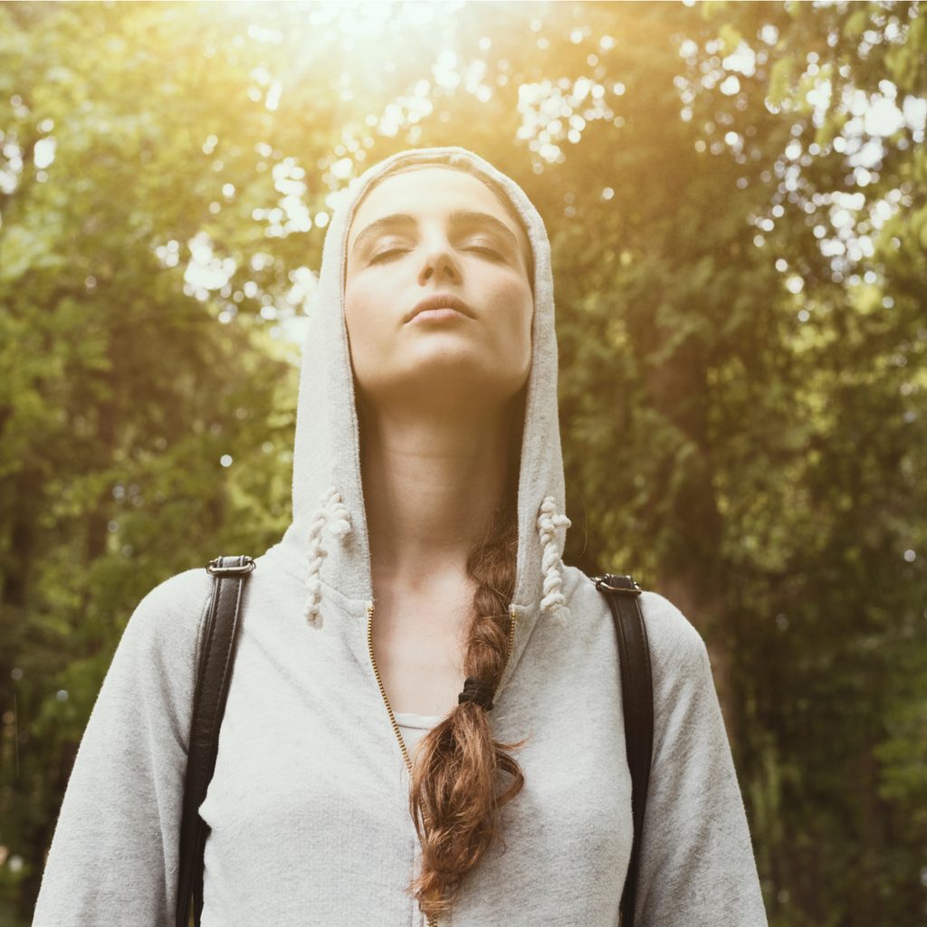 woman walking in woods with eyes closed