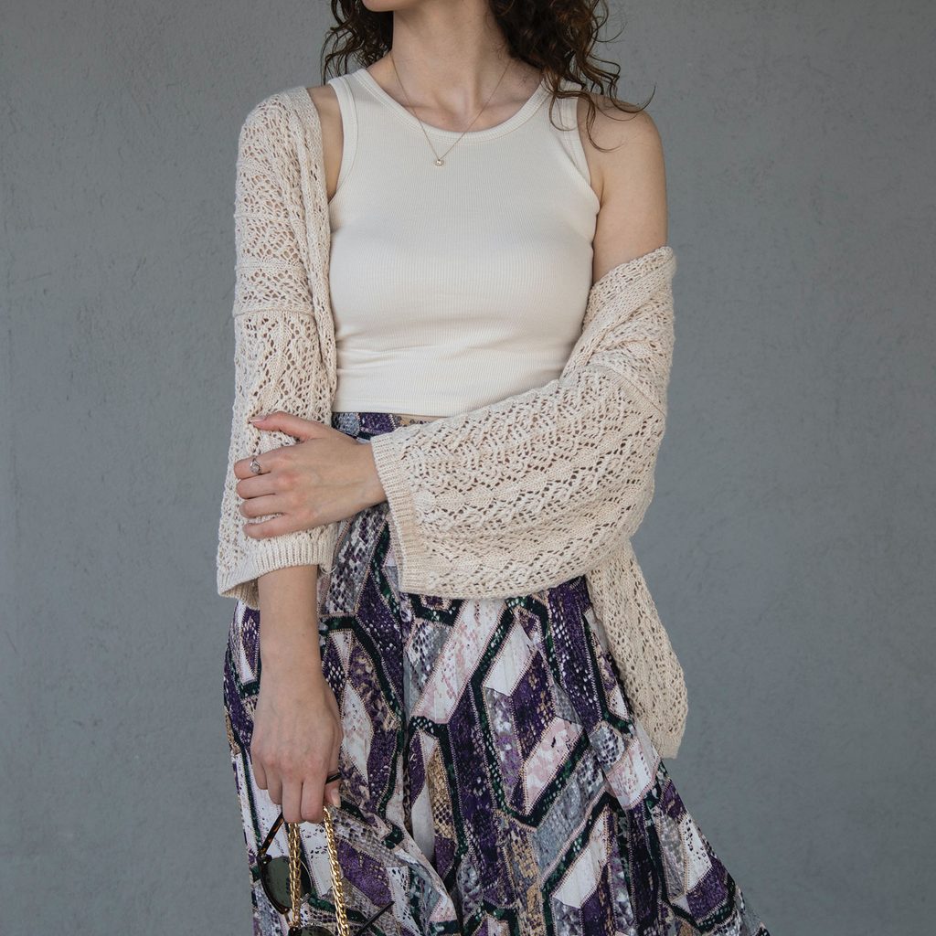 Woman wearing a tank top, cardigan, and boho skirt