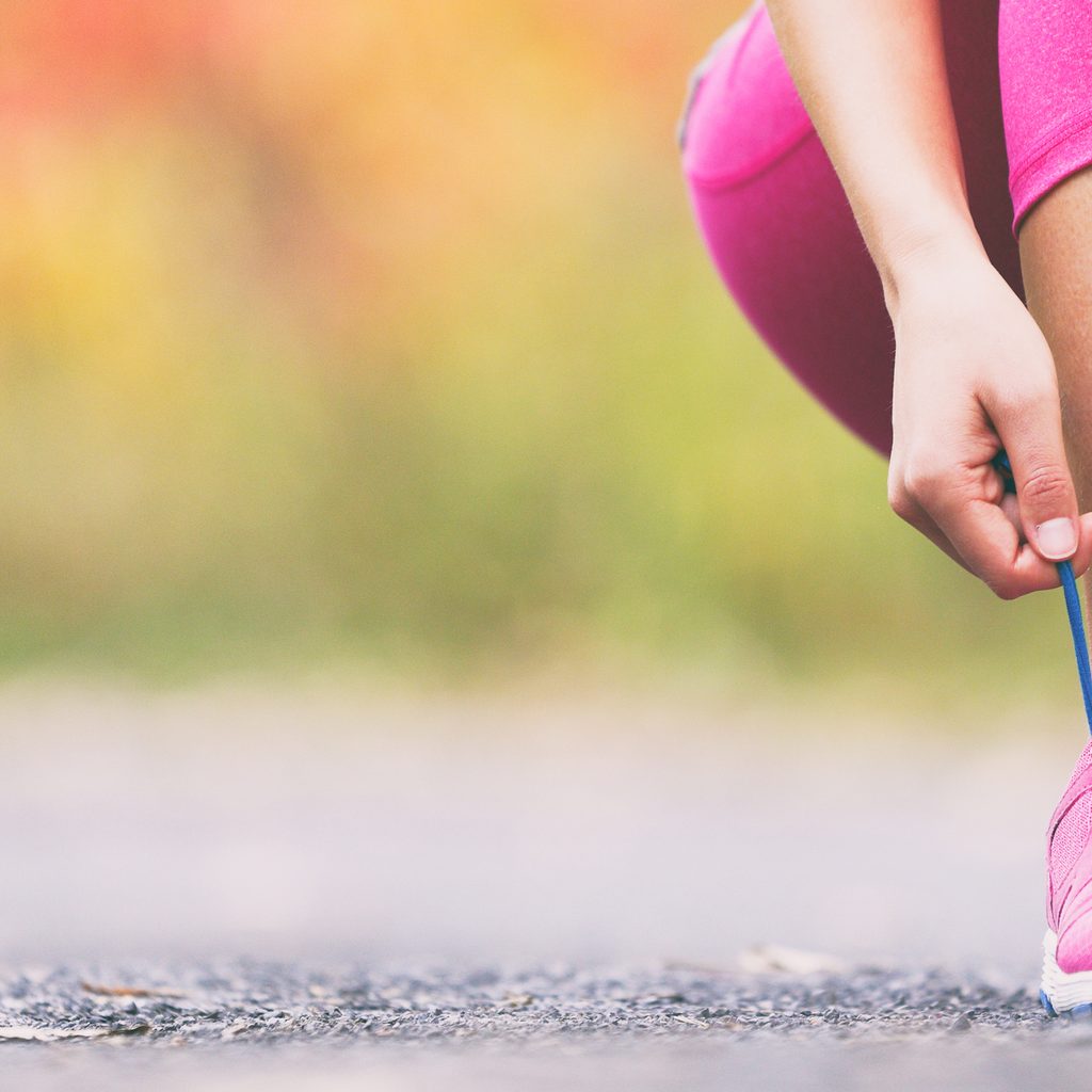 Closeup of woman tying shoe