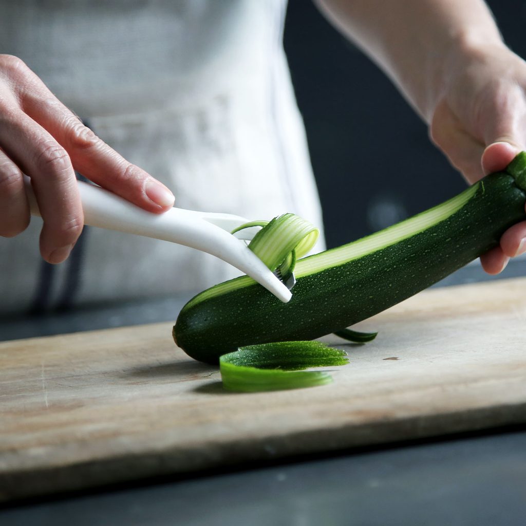 Person peeling a zucchini