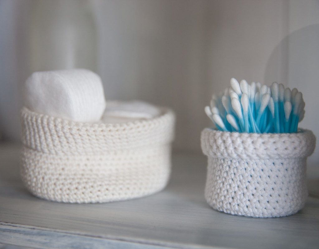 q tips in a white basket on bathroom counter