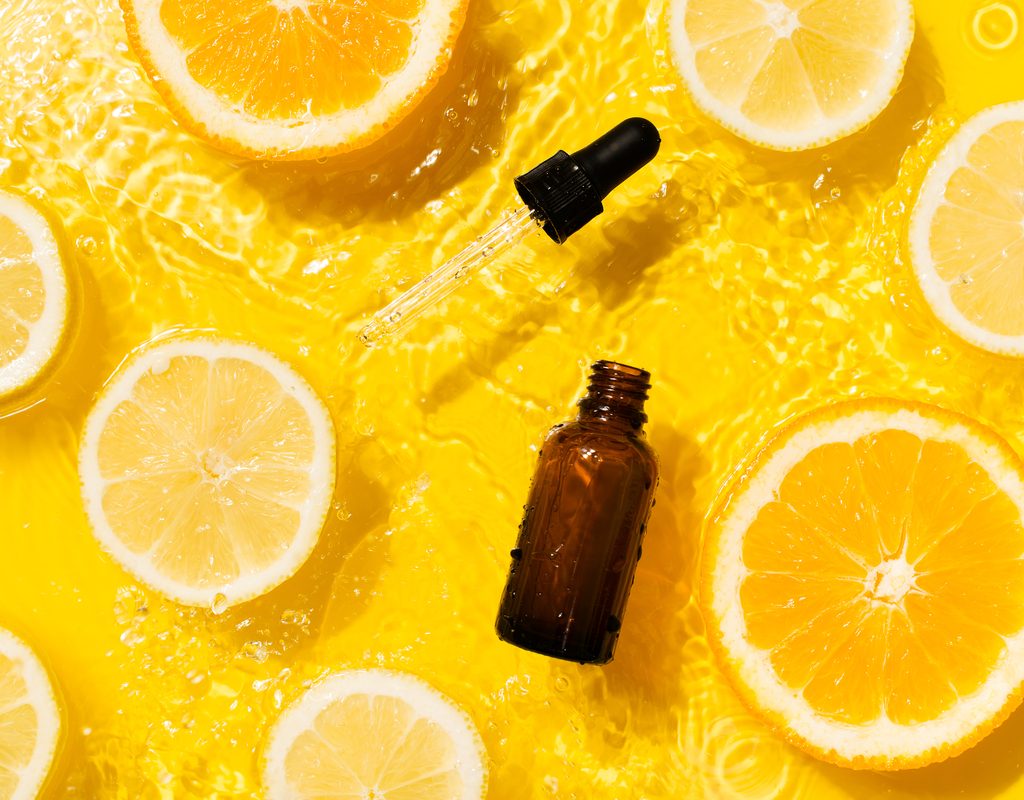 A vitamin C serum floating with orange slices.