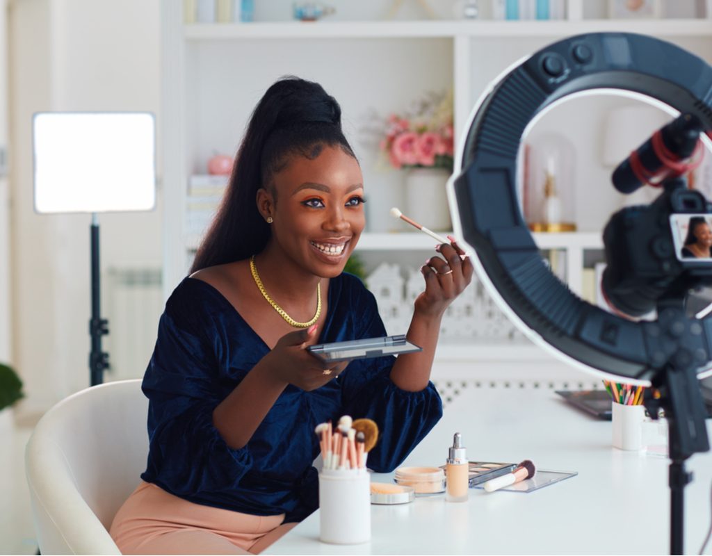 A Black woman is shooting a makeup tutorial video.
