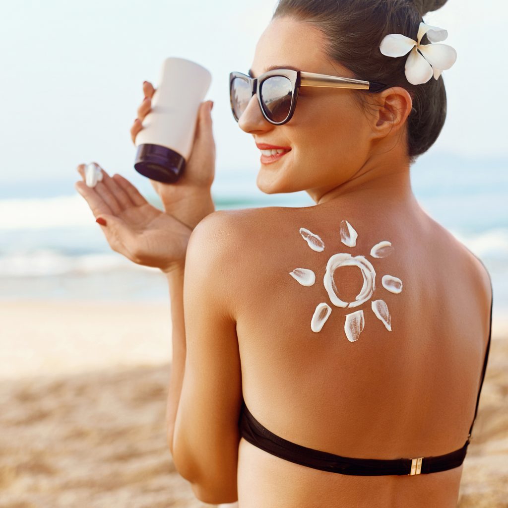 Woman applying sunscreen on the beach