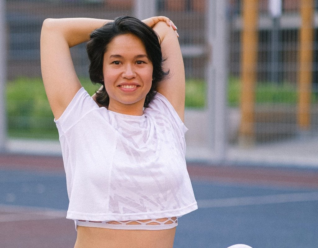 woman doing overhead tricep dip on track