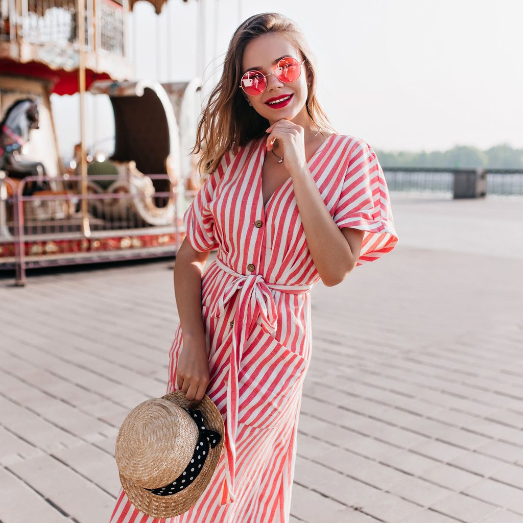 Woman in a striped dress with sunglasses and hat