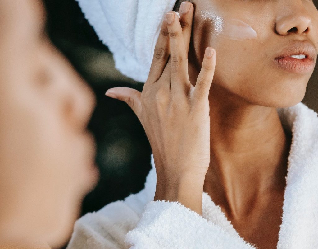 a closeup of a woman applying face cream as part of a skincare routine