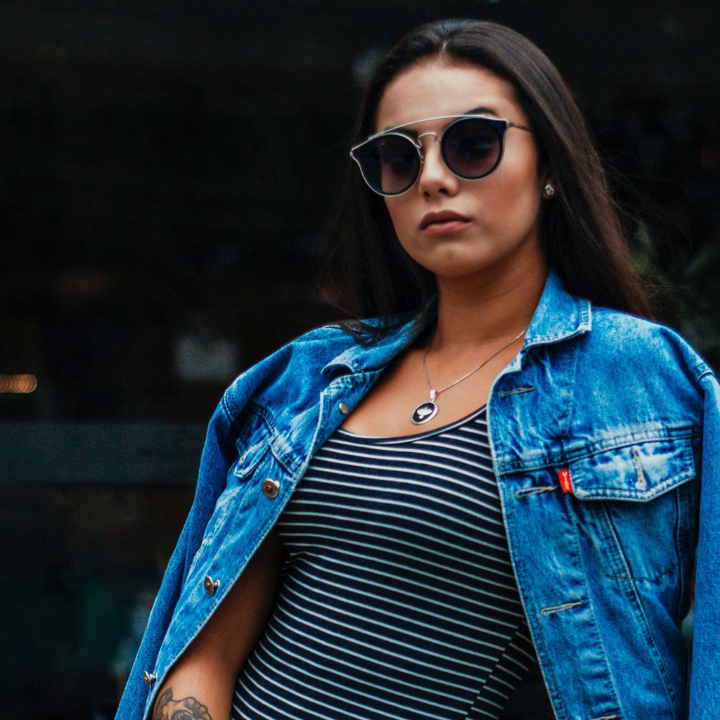 woman in a denim jacket and striped dress
