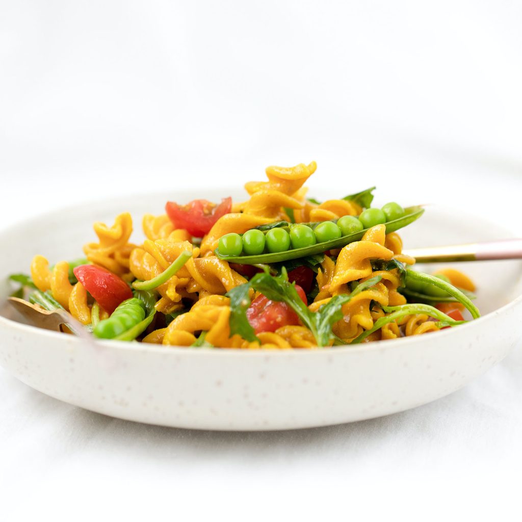 Lentil pasta with peas and tomatoes