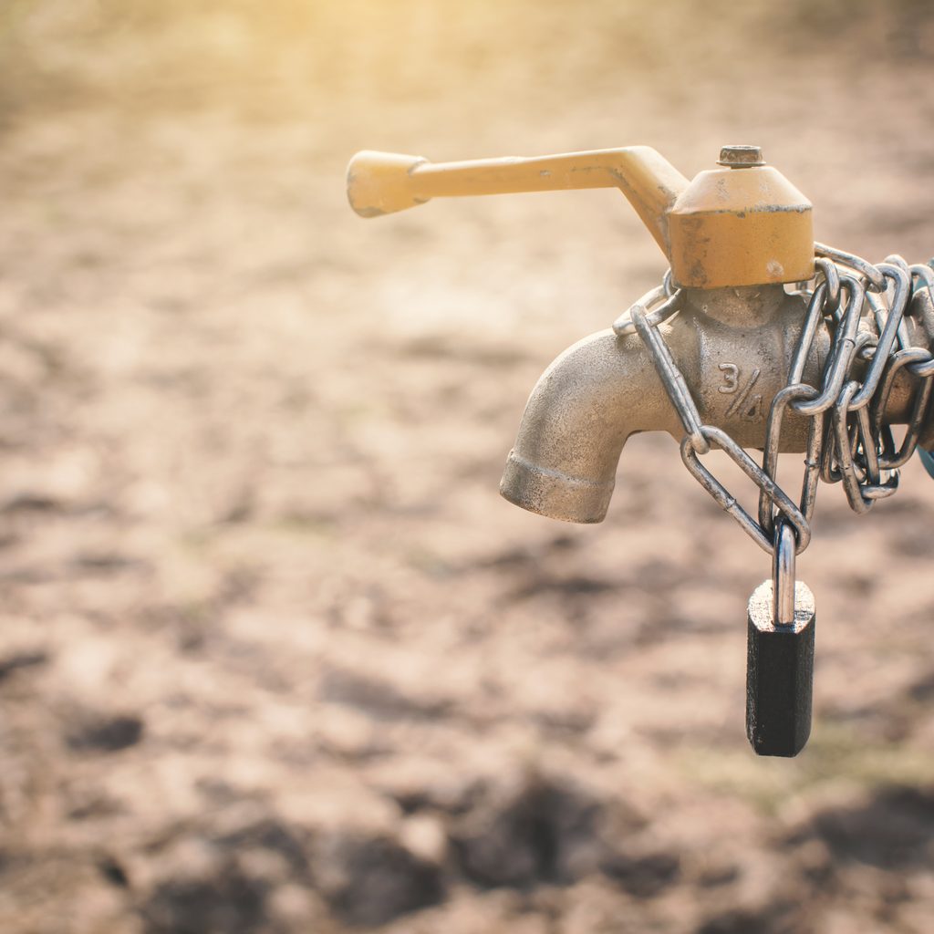 Locked water spout with dry, cracked ground behind it