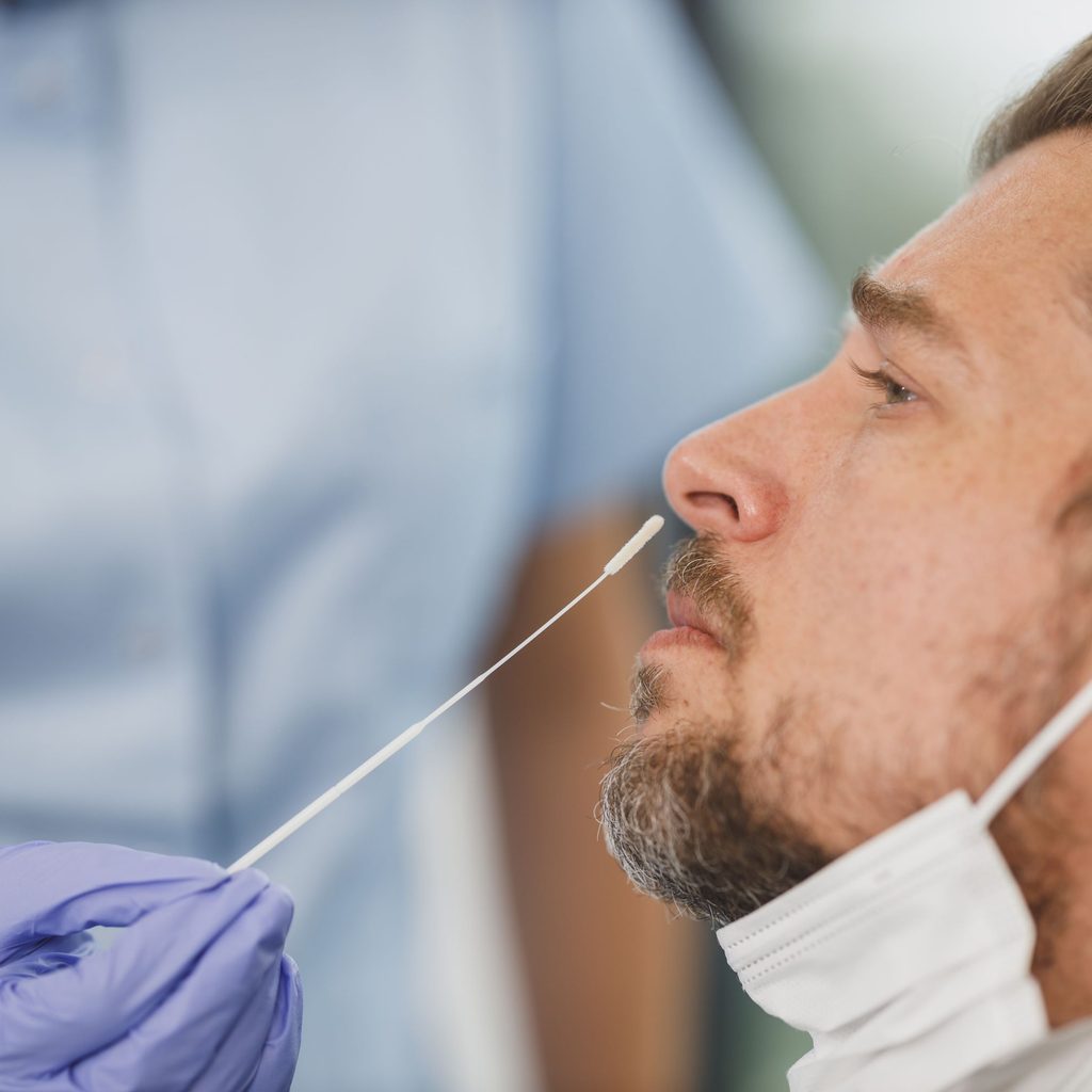 nurse giving covid-19 test to man