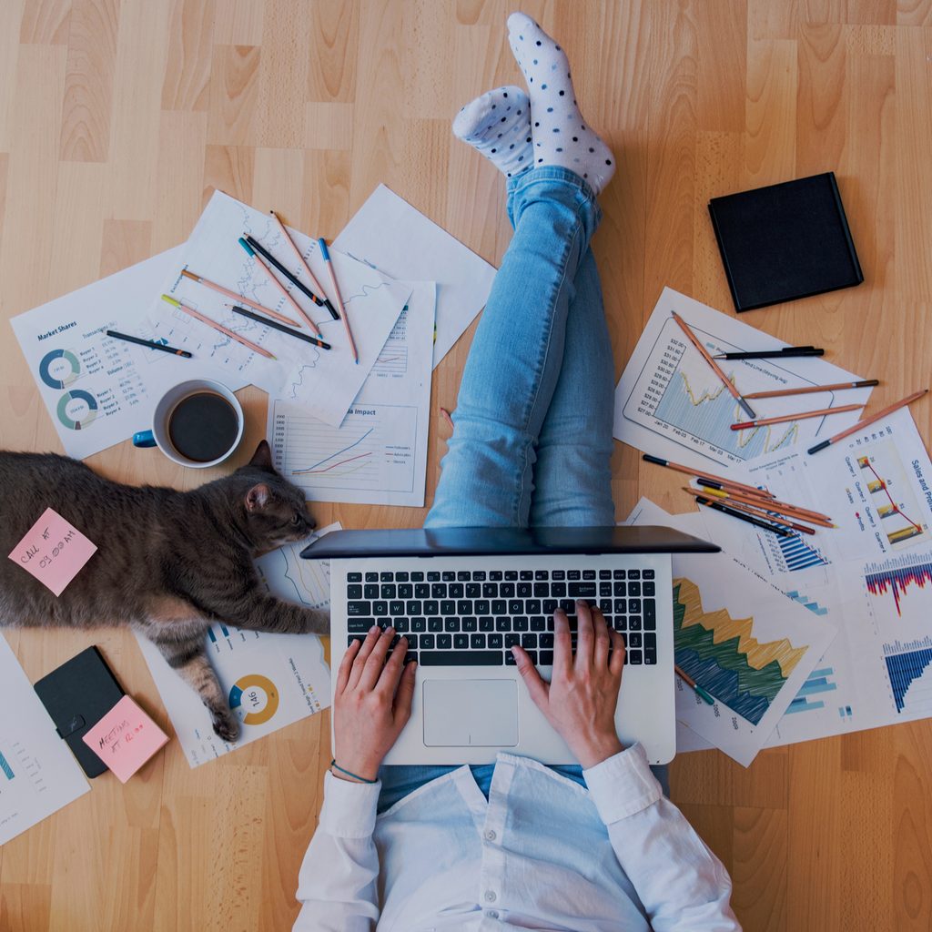 Person sitting on floor working on laptop