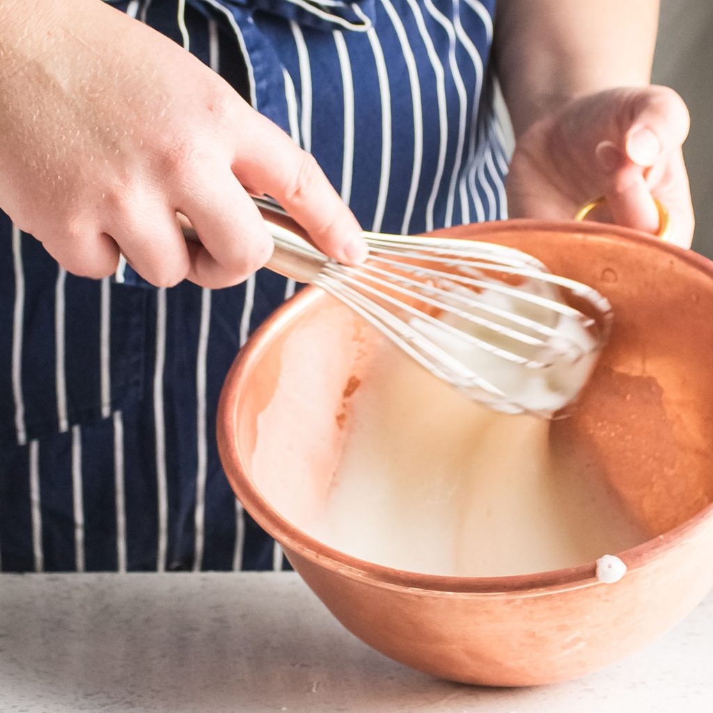 Person with a mixing bowl whisking