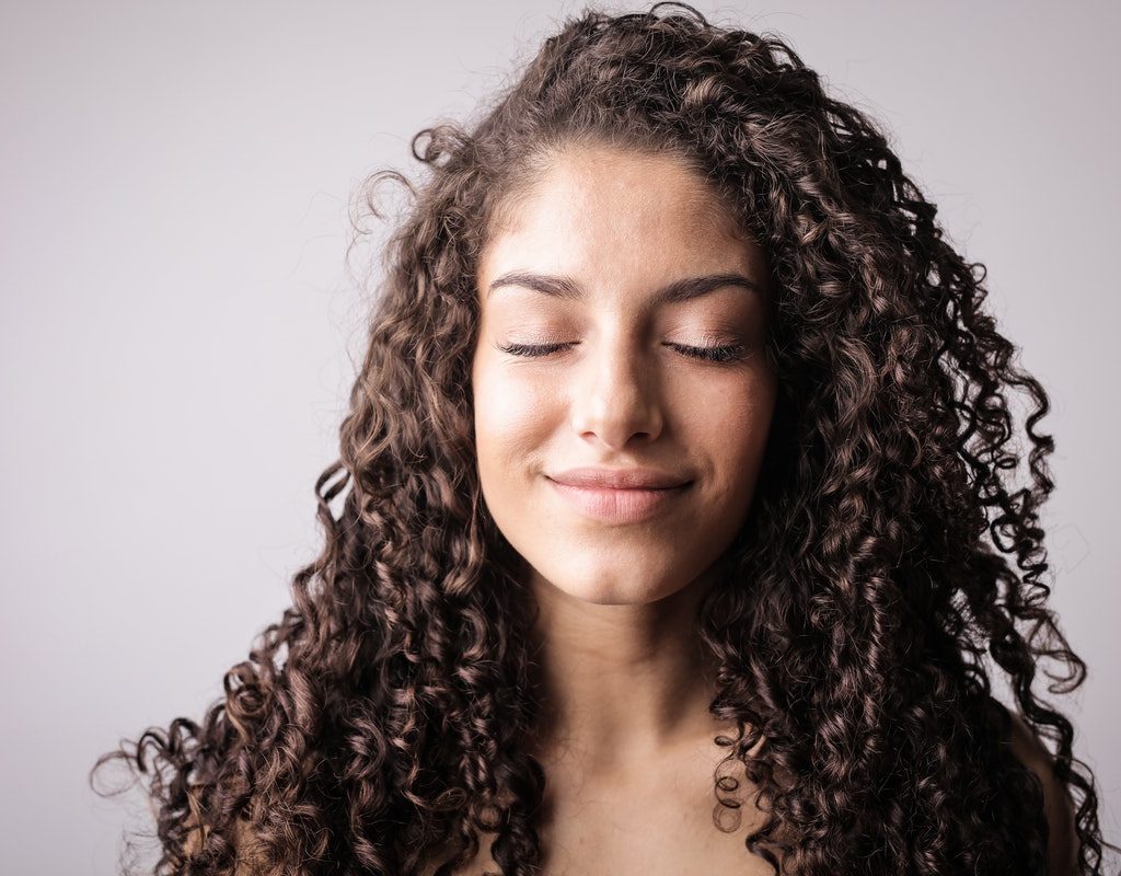 A woman with healthy, long curly hair.
