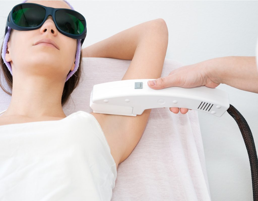 A woman getting laser hair removal on her underarms.
